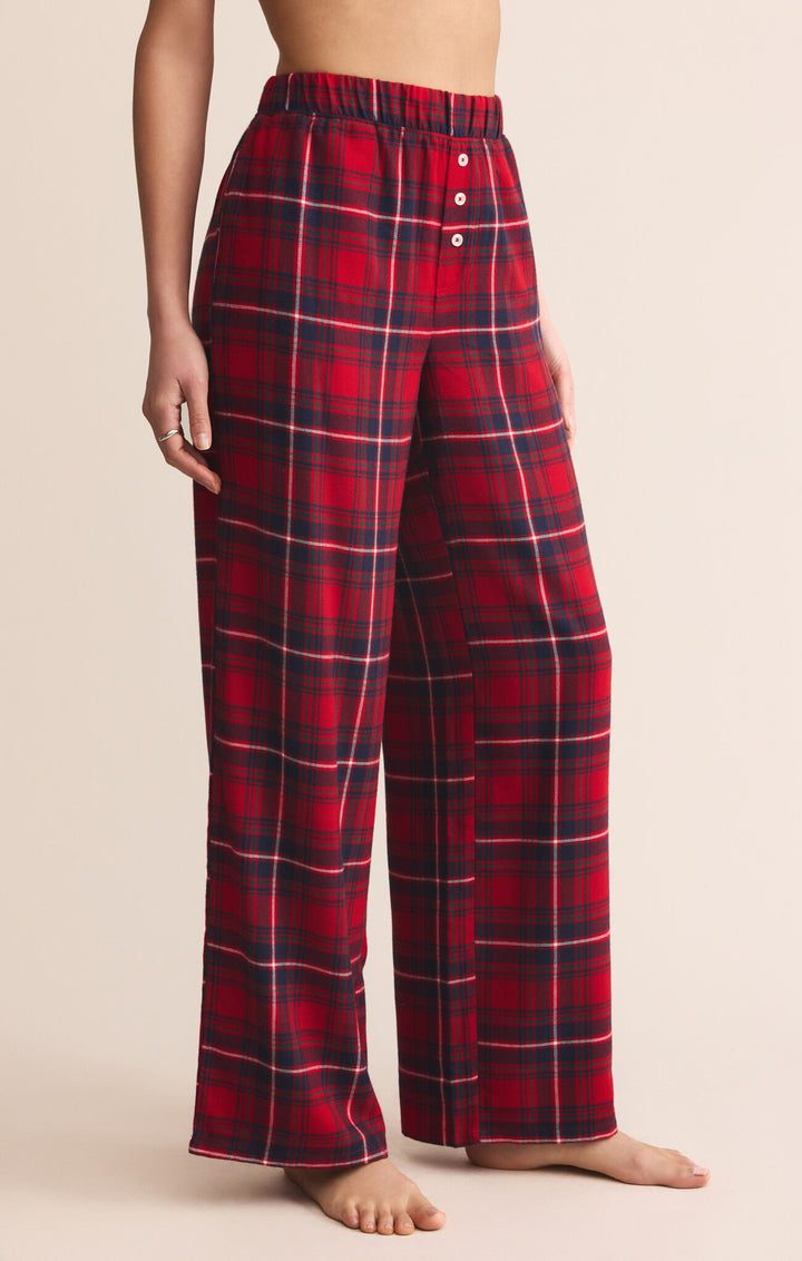 Red plaid pajama pants worn by a person on a beige background