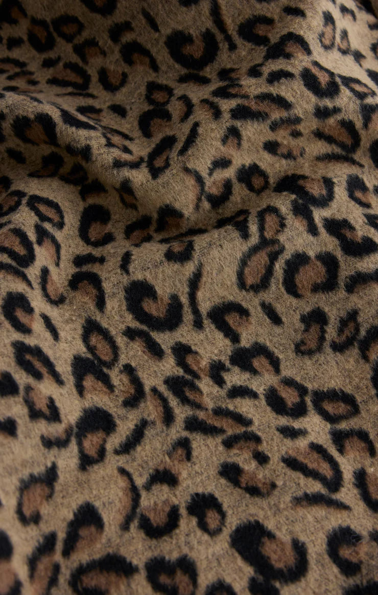 Close-up of leopard print fabric with a focus on texture and pattern.