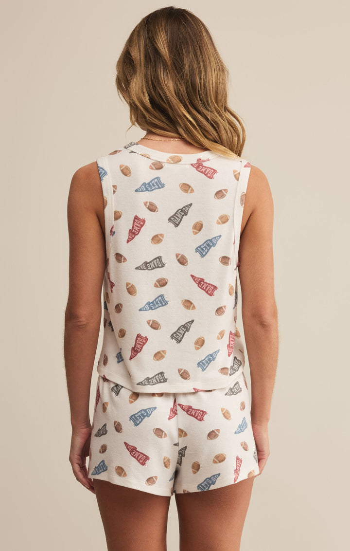 Person wearing a sleeveless top and shorts with a colorful pattern on a beige background