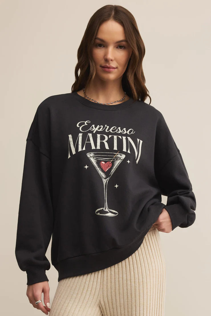 Woman wearing a black sweatshirt with 'Espresso Martini' design on a beige background