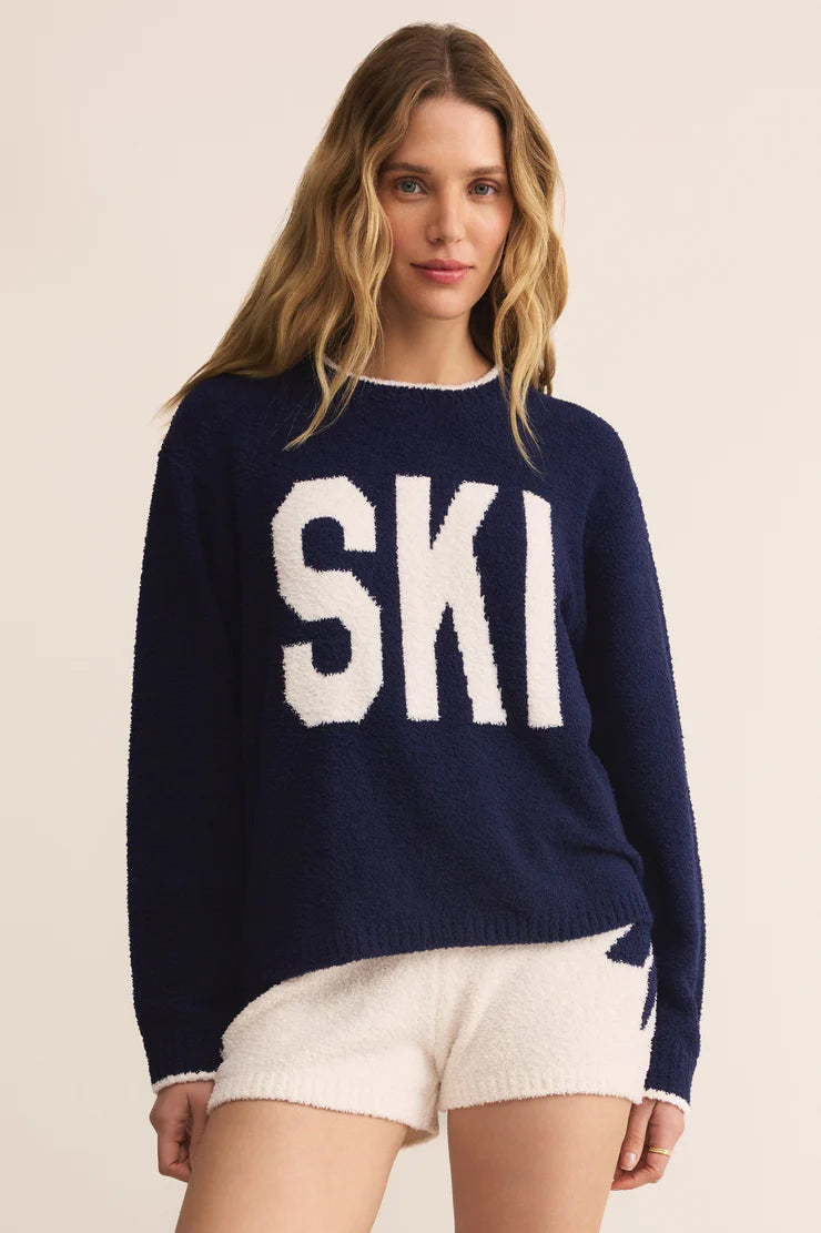 Woman wearing a navy blue sweater with 'SKI' in white letters on a beige background
