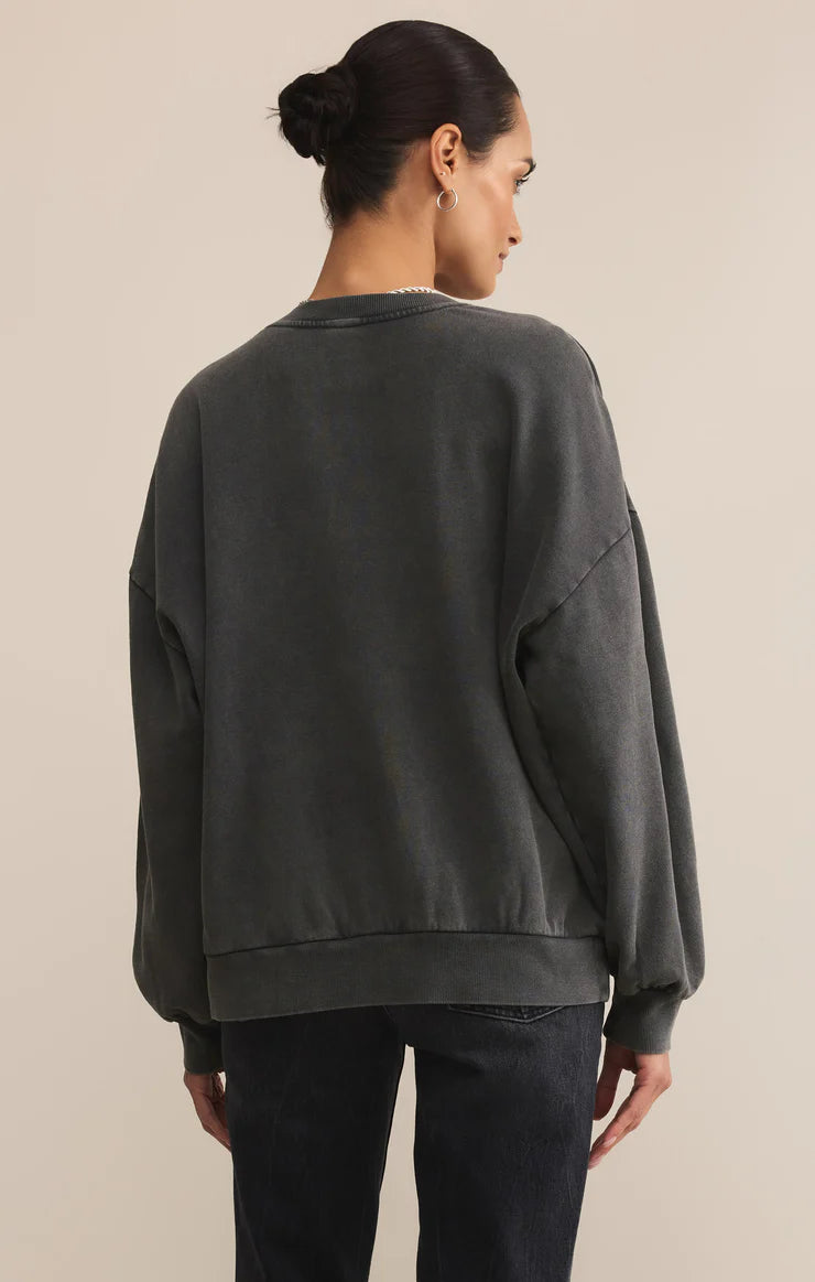 Person wearing a dark gray sweatshirt on a beige background