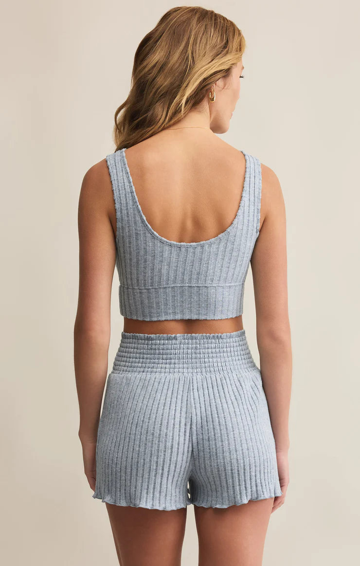Woman wearing a light blue ribbed crop bra top and shorts set on a beige background