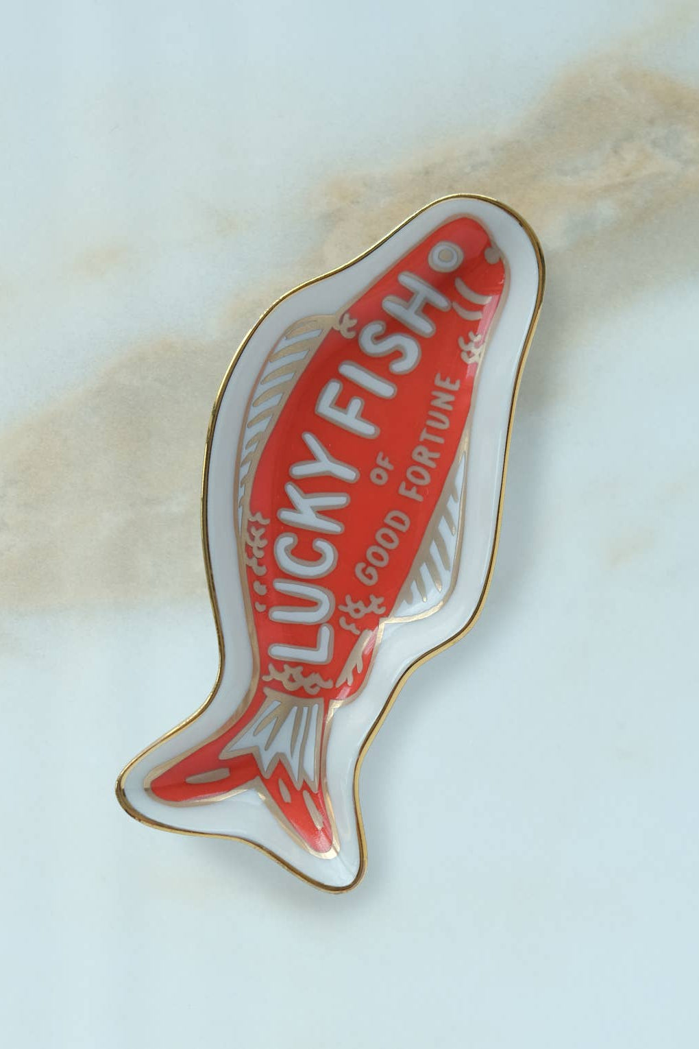 Lucky Fish pin with red and gold design on a light background