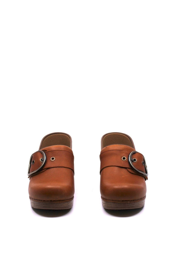 classic clog style with roomy toe box and cork footbed, features a large buckle detail in a tan leather from dansko