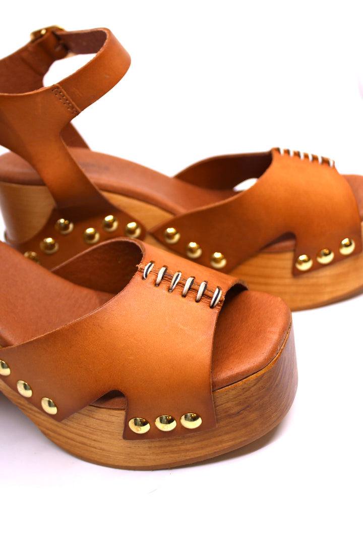 Free People Cecily Studded Clog Luggage top view- Dear Lucy
Platform, heeled clog with a wooden base and tan leather upper toe strap and ankle strap with studding throughout. 