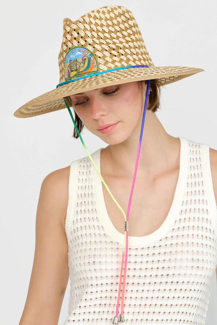Freya Not All Those Who Wander Lifeguard Hat  front view- Dear Lucy
Natural and tan woven straw lifeguard hat with a patch on the front featuring a camel saying "Not all those who wander are lost" with a rainbow colored adjustable strap.