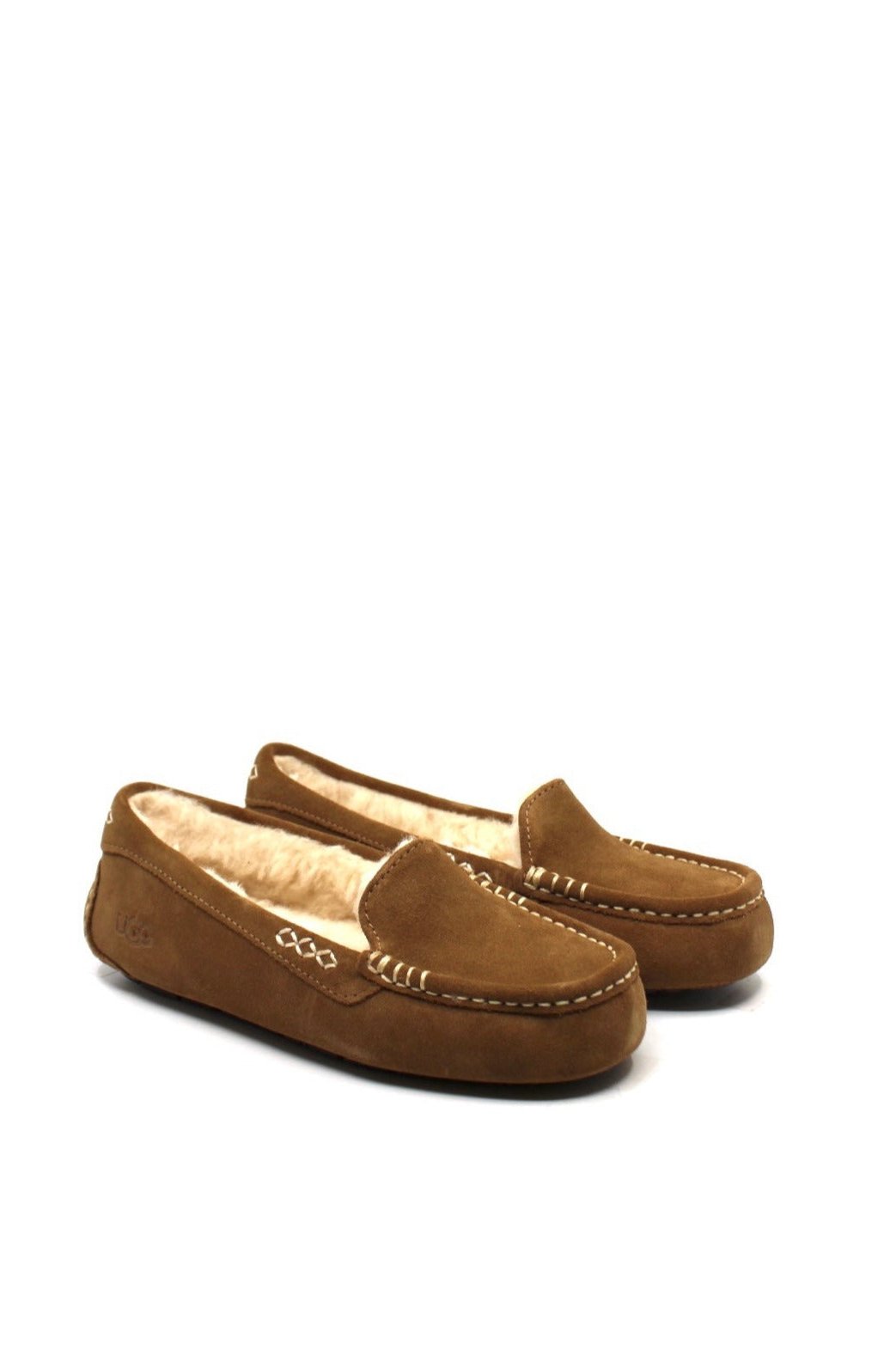 A pair of chestnut colored UGG Ansley slippers with a closed toe and decorative stitching on a white background.