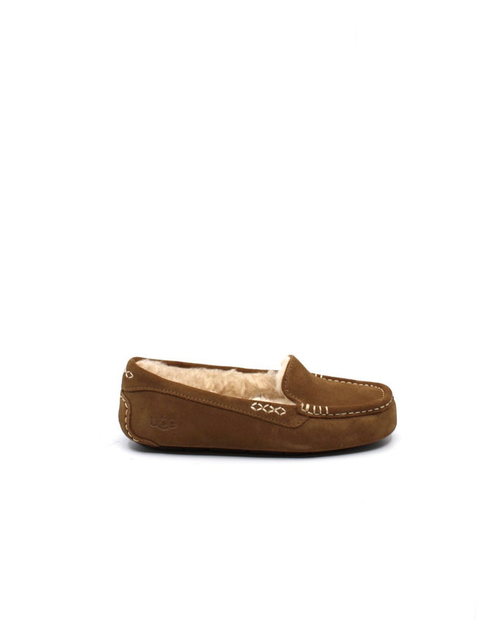 A pair of chestnut colored UGG Ansley slippers with a closed toe and decorative stitching on a white background.