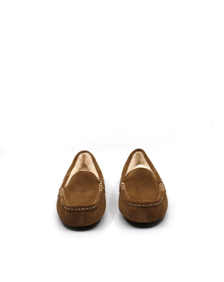 A pair of chestnut colored UGG Ansley slippers with a closed toe and decorative stitching on a white background.