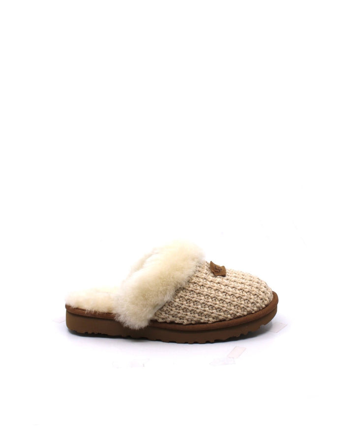 A pair of beige UGG Cozy Cream slippers with a sheepskin lining and a fluffy collar.